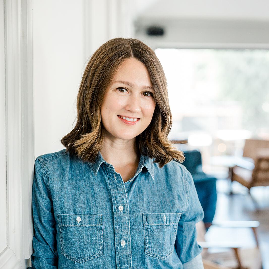 Laura Roeder, founder of Paperbell, smiling in a bright, modern room.