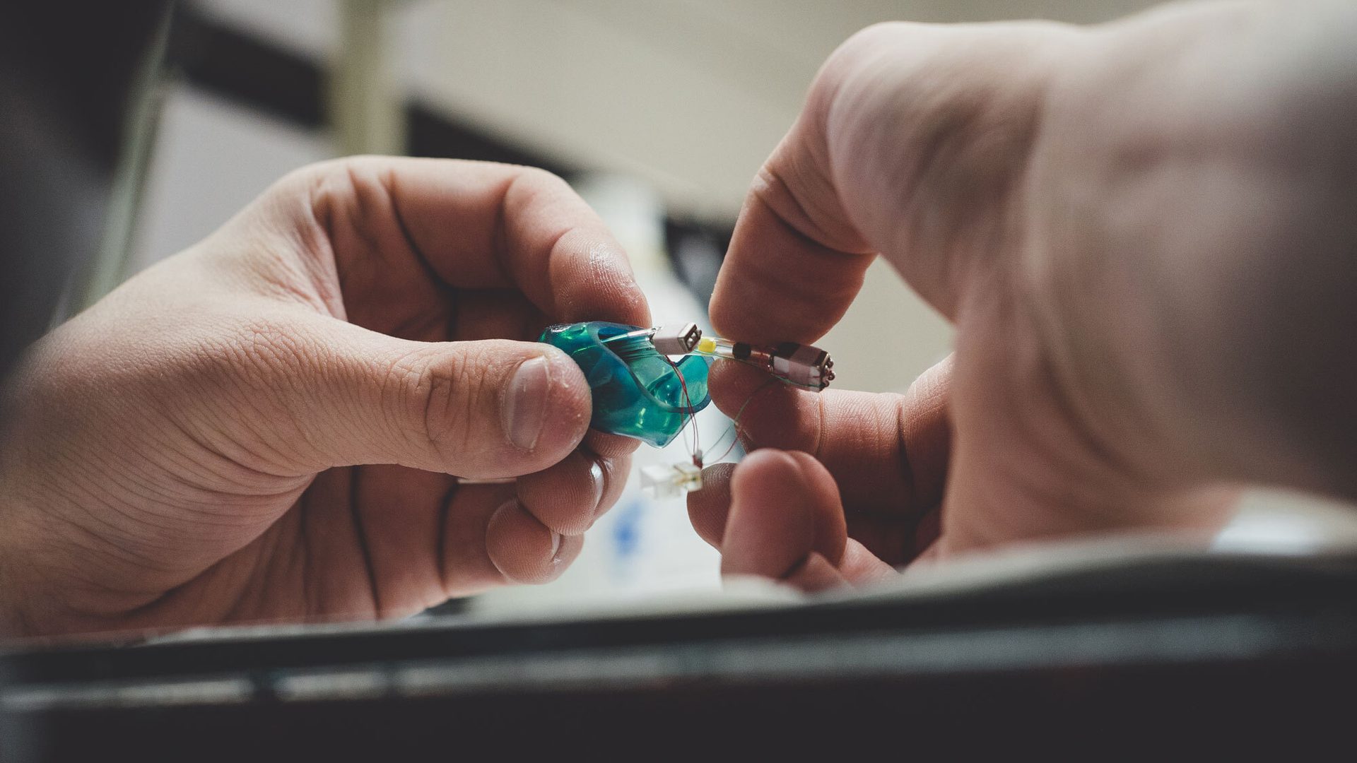Hands holding a custom made Alclair earpiece