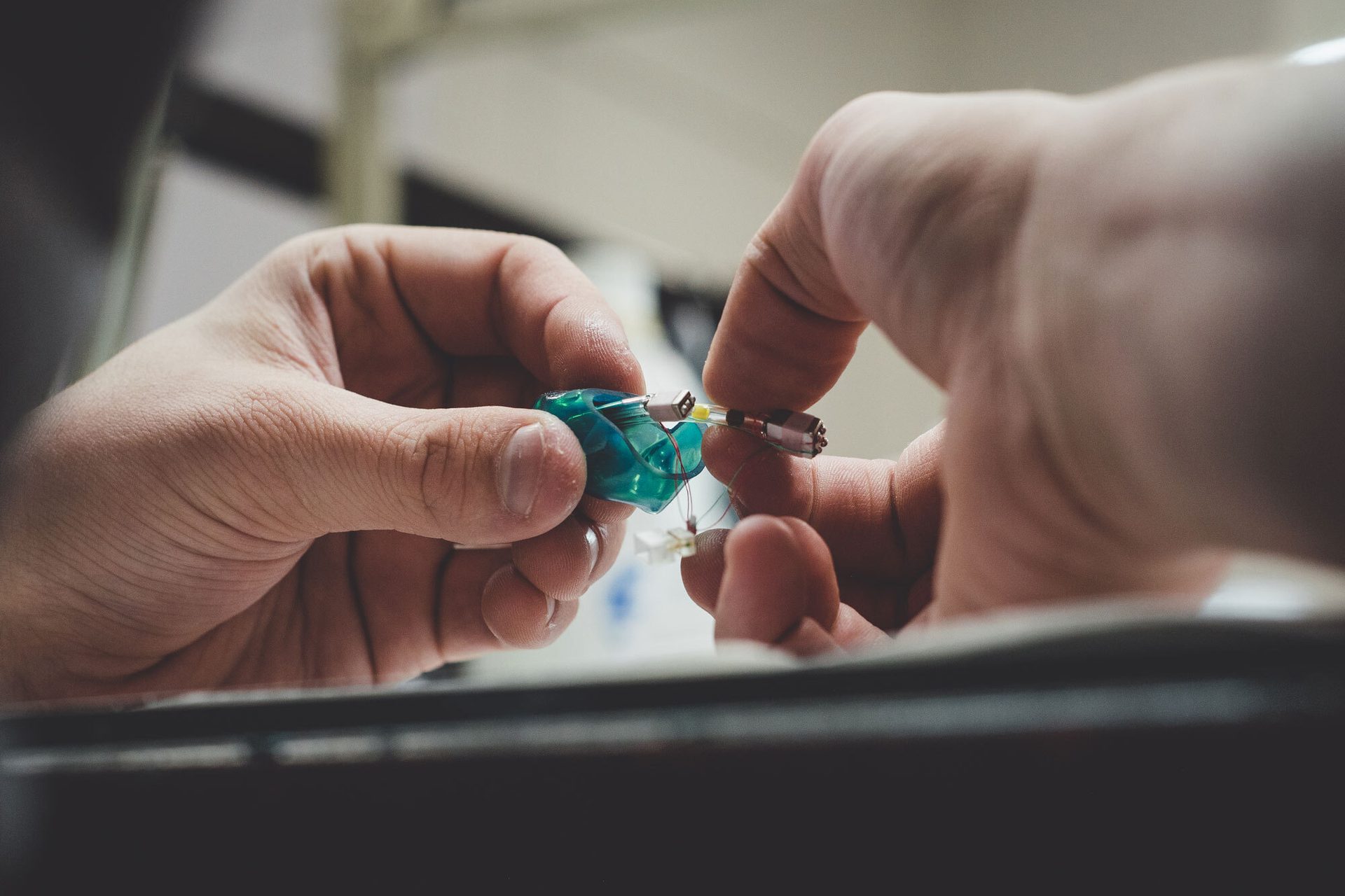 Hands holding a custom made Alclair earpiece