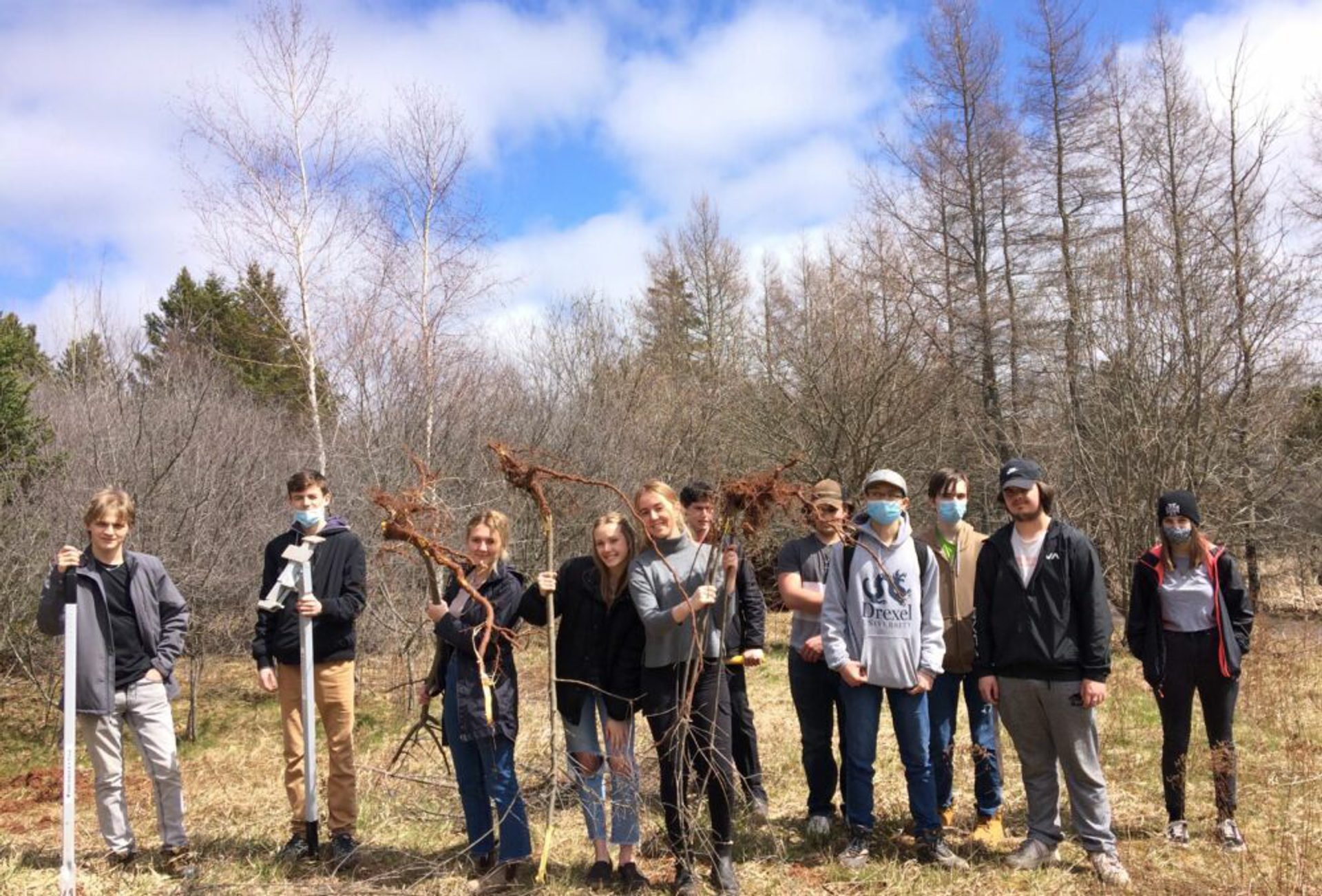 Young volunteers smiling while cleaning up wetlands