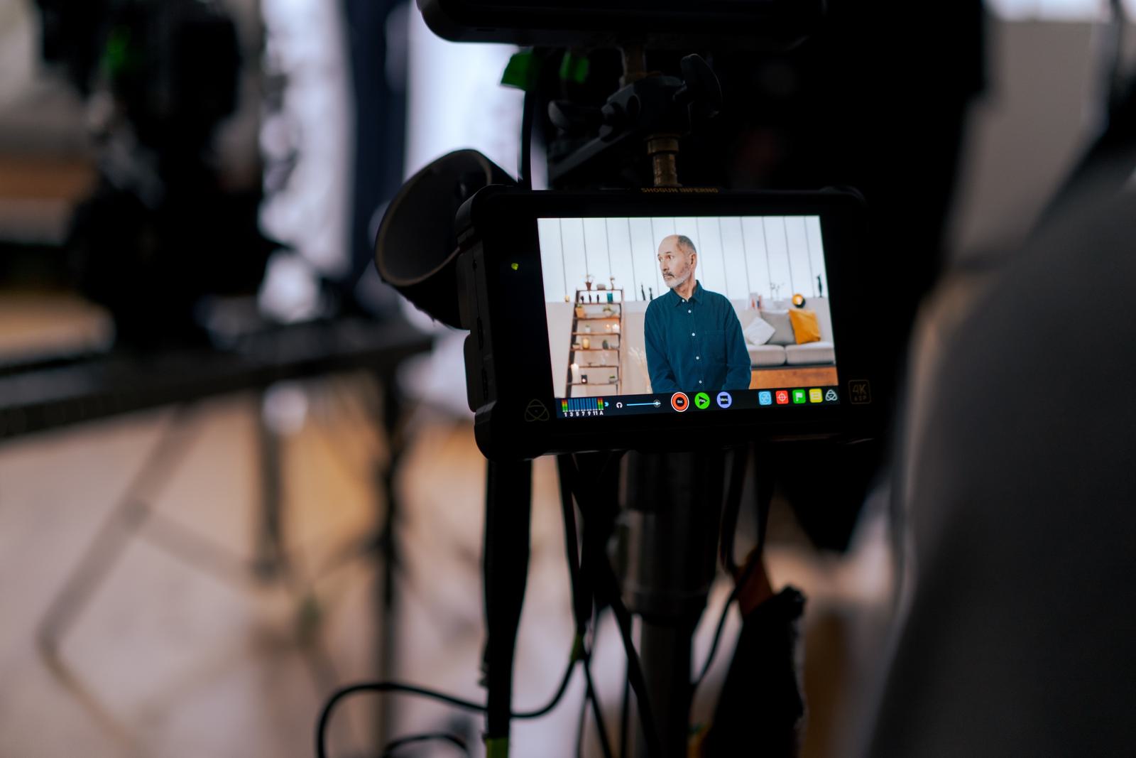 A camera is recording an older man teaching an online course