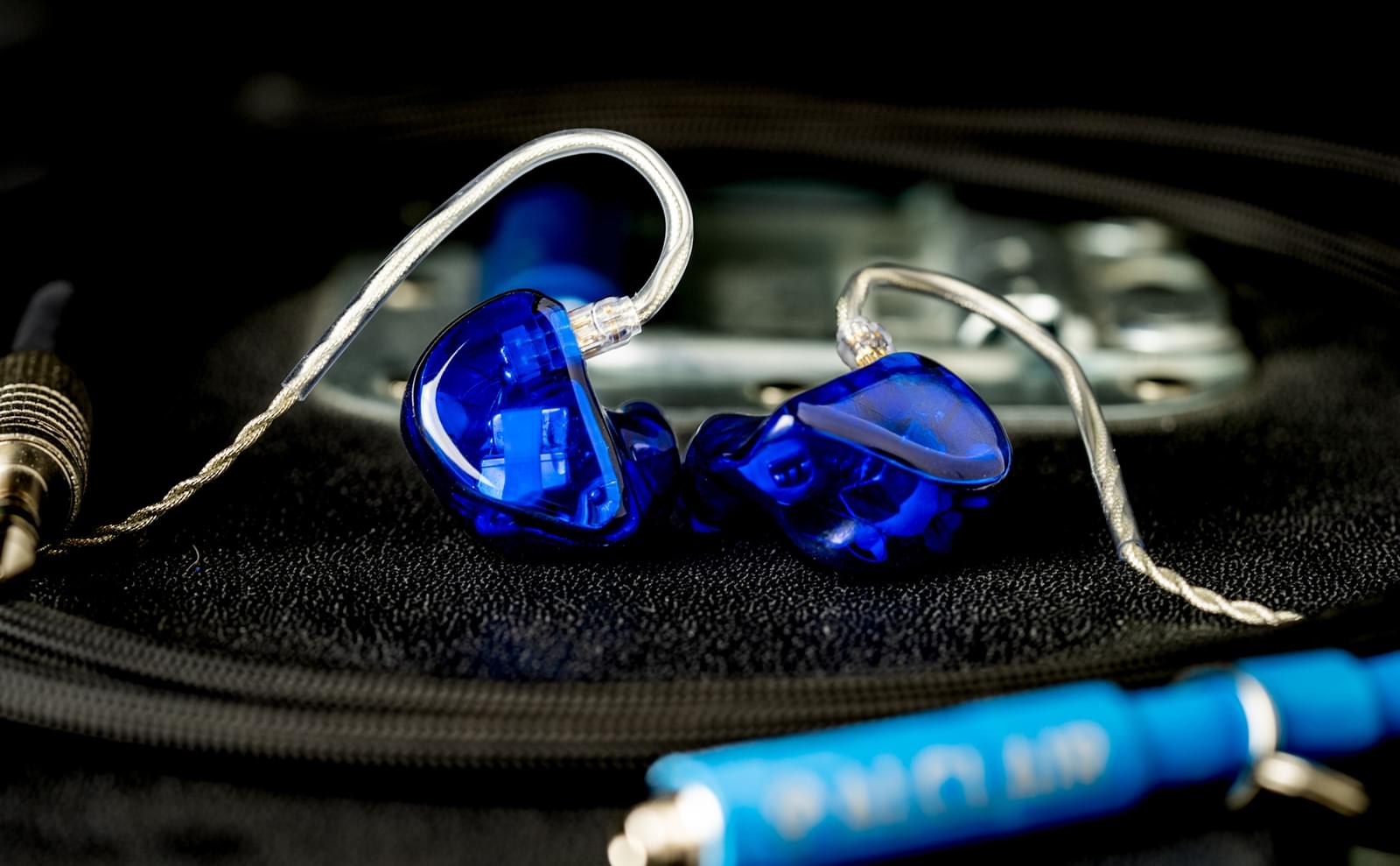 A pair of blue Alcair earpieces on a table